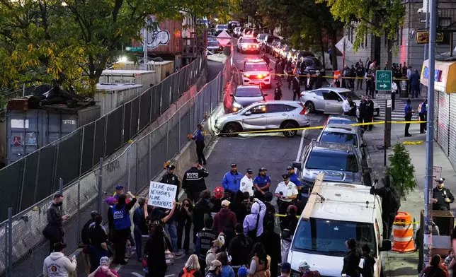 People gather at the scene of a shooting as law enforcement work the area Thursday, Oct. 8, 2026, in New York. (AP Photo/Seth Wenig)