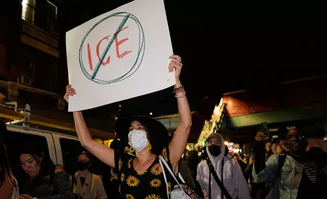 A person holds a sign near the scene of a shooting Thursday, Oct. 8, 2026, in New York. (AP Photo/Seth Wenig)