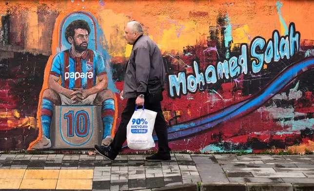 A man walks past a mural depicting Trabzonspor's Egyptian soccer player Mohamed Salah wearing the club's claret and light blue jersey in Trabzon, Turkey, Tuesday, Oct. 20, 2026. (AP Photo/Khalil Hamra)