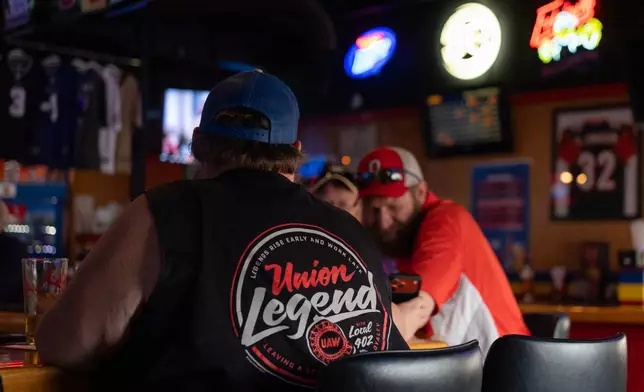 UAW Local 402 members including Joe Penwell, left, have a drink at Fricker's restaurant and bar in Springfield, Ohio, on Wednesday, Sept. 30, 2026, on old Navistar's last day at its Springfield plant. (AP Photo/Carolyn Kaster)