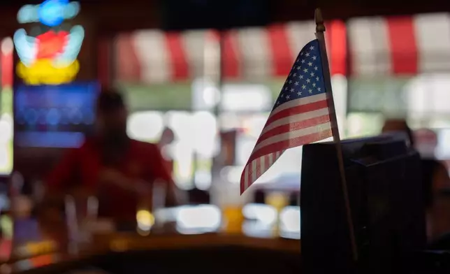 An American flag is posted on the register at Fricker's restaurant and bar in Springfield, Ohio, on Wednesday, Sept. 30, 2026, as UAW Local 402 members have a drink on old Navistar's last day at its Springfield plant. (AP Photo/Carolyn Kaster)