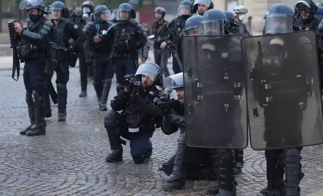 Police face students after a march to protest against under-resourced schools in Paris, Tuesday Oct. 13, 2026. (AP Photo/Thibault Camus)