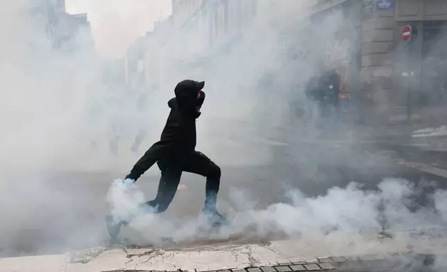 A protester throws a teargas canister to police after a demonstration against rising living costs in Rennes, France, Saturday, Oct. 24, 2026. (AP Photo/Jeremias Gonzalez)