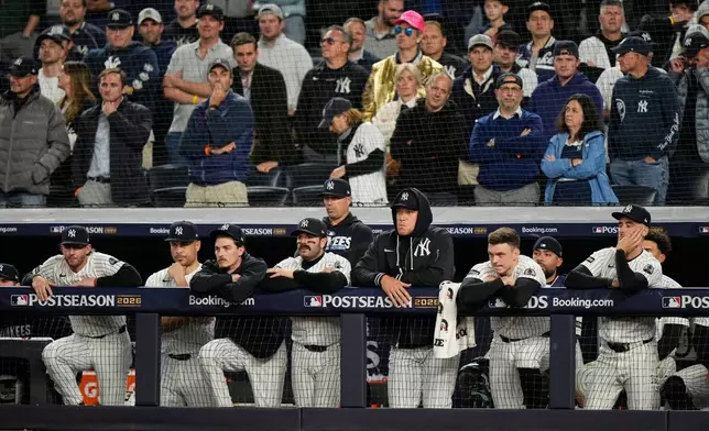 New York Yankees players stand at the top of the dugout watching play against the Tampa Bay Rays during the ninth inning in Game 3 of baseball's American League Division Series, Wednesday, Oct. 7, 2026, in New York. (AP Photo/Seth Wenig)