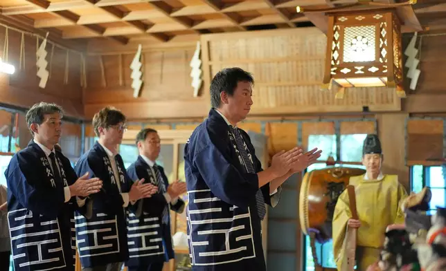 Representatives from a traditional Japanese doll company offer prayers for dolls no longer used by their owners during a traditional doll memorial ceremony at Dairokuten Sakaki Shrine Tuesday, Oct. 13, 2026, in Tokyo. (AP Photo/Eugene Hoshiko)