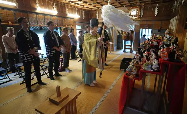 A Shinto priest offers prayers for dolls no longer used by their owners during a traditional doll memorial ceremony at Dairokuten Sakaki Shrine Tuesday, Oct. 13, 2026, in Tokyo. (AP Photo/Eugene Hoshiko)