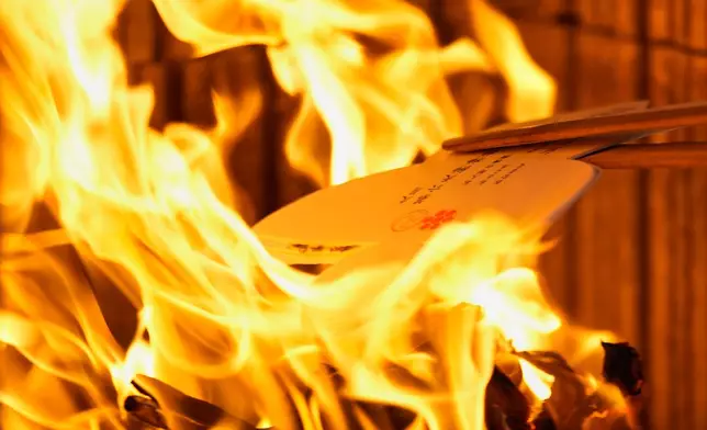 Doll-shaped paper cutouts are burned as part of a prayer ritual during a doll memorial ceremony at Dairokuten Sakaki Shrine in Tokyo, Tuesday, Oct. 13, 2026. (AP Photo/Eugene Hoshiko)
