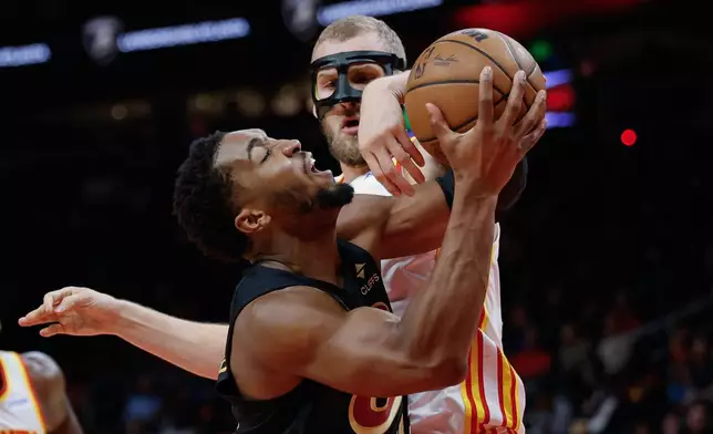 Cleveland Cavaliers guard Donovan Mitchell, left, is fouled by Atlanta Hawks center Jock Landale, right, during the first half of an NBA basketball game, Thursday, Oct. 29, 2026, in Atlanta. (AP Photo/Erik S. Lesser)