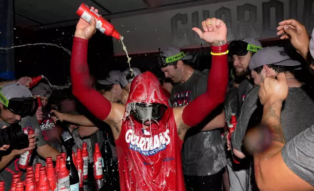 Cleveland Guardians shortstop Brayan Rocchio celebrates with teammates in the locker room after Game 5 of baseball's American League Division Series against the Chicago White Sox, Saturday, Oct. 10, 2026, in Cleveland. (AP Photo/Sue Ogrocki)