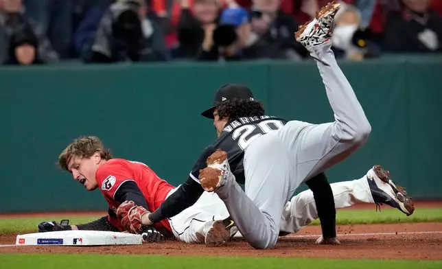 Cleveland Guardians' Petey Halpin is tagged out at third base by Chicago White Sox third baseman Miguel Vargas (20) during the fifth inning of Game 5 of baseball's American League Division Series, Saturday, Oct. 10, 2026, in Cleveland. (AP Photo/Sue Ogrocki)