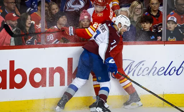 Colorado Avalanche's Devon Toews, front, checks Calgary Flames' Samuel Honzek, back, during the second period of an NHL hockey game in Calgary, Alberta, Thursday, Oct. 8, 2026. (Jeff McIntosh/The Canadian Press via AP)