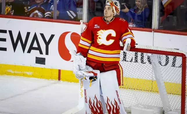 Calgary Flames goalie Devin Cooley looks to the scoreboard after letting in a goal during the third period of an NHL hockey game against the Colorado Avalanche in Calgary, Alberta, Thursday, Oct. 8, 2026. (Jeff McIntosh/The Canadian Press via AP)