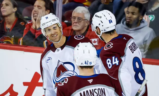 Colorado Avalanche's Jaden Schwartz, left, celebrates after his goal with teammates during the third period of an NHL hockey game against the Calgary Flames in Calgary, Alberta, Thursday, Oct. 8, 2026. (Jeff McIntosh/The Canadian Press via AP)