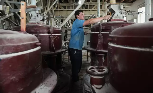 Eric Gifford, head miller at The Birkett Mills, takes a sample of unhulled buckwheat seeds before they are ground Wednesday, Aug. 19, 2026, in Penn Yan, N.Y. (AP Photo/Joshua A. Bickel)