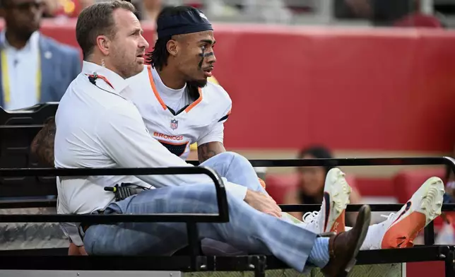 Denver Broncos wide receiver Pat Bryant, right, is carted off the field during the second half of an NFL football game against the San Francisco 49ers in Santa Clara, Calif., Sunday, Oct. 4, 2026. (AP Photo/Justine Willard)