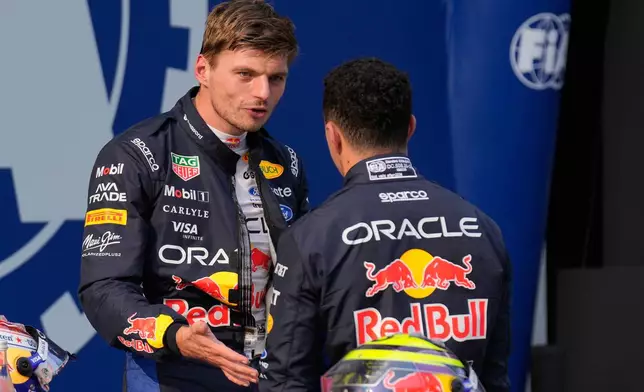 Red Bull driver Max Verstappen of the Netherlands, pole position, talks with his teammate Isack Hadjar of France, third fastest time after the qualifying session ahead of the Bahrain Grand Prix in Sepang, Malaysia, Saturday, Oct. 3, 2026. (AP Photo/Aijaz Rahi)