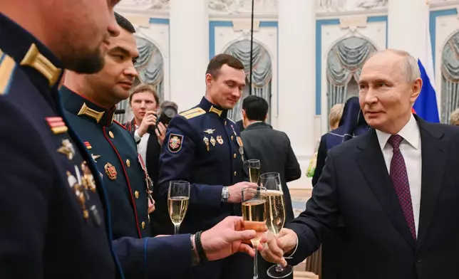 Russian President Vladimir Putin, right, toasts with Russian soldiers during a meeting with teachers at the Kremlin in Moscow, Monday, Oct. 5, 2026. (Kristina Solovyova, Sputnik, Kremlin Pool Photo via AP)
