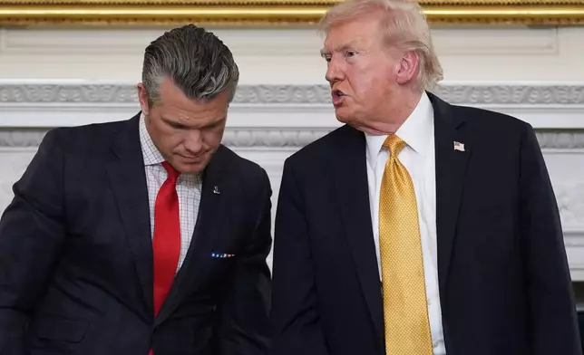 FILE - President Donald Trump talks with Defense Secretary Pete Hegseth after a roundtable on criminal cartels in the State Dining Room of the White House, Oct. 23, 2025, in Washington. (AP Photo/Evan Vucci, File)