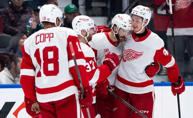 Detroit Red Wings' Anton Johansson, right, celebrates after his goal against the Vancouver Canucks with teammates during the second period of an NHL hockey game in Vancouver, British Columbia, Thursday, Oct. 22, 2026. (Ethan Cairns/The Canadian Press via AP)