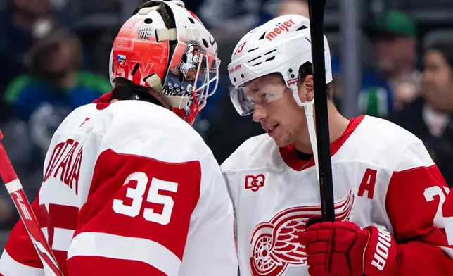 Detroit Red Wings goaltender Michal Postava (35) and Lucas Raymond (23) celebrate after defeating the Vancouver Canucks in an NHL hockey game in Vancouver, British Columbia, Thursday, Oct. 22, 2026. (Ethan Cairns/The Canadian Press via AP)