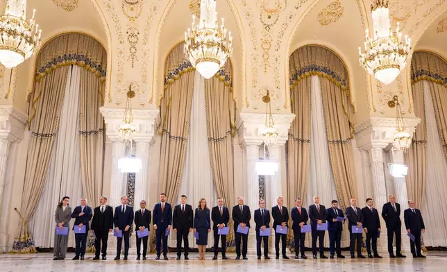 Ministers of the Luca Niculescu cabinet stand during a swearing in ceremony at the Cotroceni Presidential Palace, in Bucharest, Romania, Tuesday, Oct. 20, 2026. (AP Photo/Andreea Alexandru)