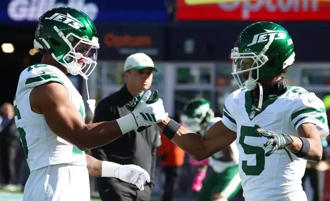 New York Jets wide receiver Garrett Wilson (5) shakes hands with tight end Kenyon Sadiq, left, before an NFL football gam against the New England Patriotse in Foxborough, Mass., Sunday, Oct. 18, 2026. (AP Photo/Mark Stockwell)