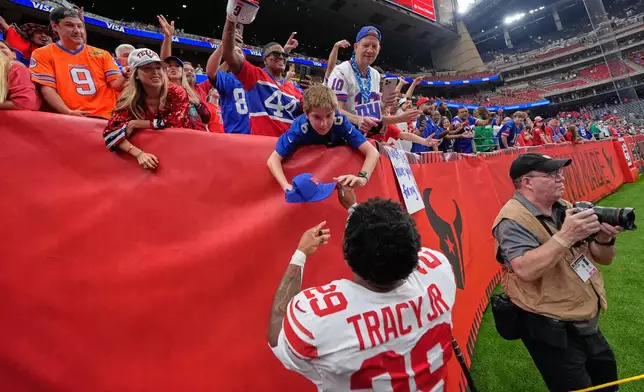 New York Giants running back Tyrone Tracy Jr. (29) gives autographs to fans after an overtime win over the Houston Texans in an NFL football game in Houston, Sunday, Oct. 25, 2026. (AP Photo/Gerald Herbert)