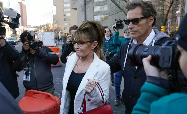 FILE - Sarah Palin is escorted to her car by Ron Duguay after leaving the courthouse in New York, Thursday, Feb. 10, 2022. (AP Photo/Seth Wenig, File)