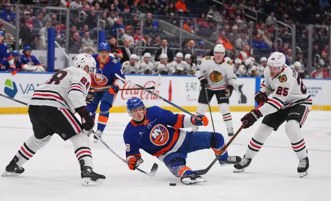 Chicago Blackhawks' Ian Cole (28) and Dominic Toninato (25) defend New York Islanders' Victor Eklund (38) during the second period of an NHL hockey game Thursday, Oct. 8, 2026, in Elmont, N.Y. (AP Photo/Frank Franklin II)
