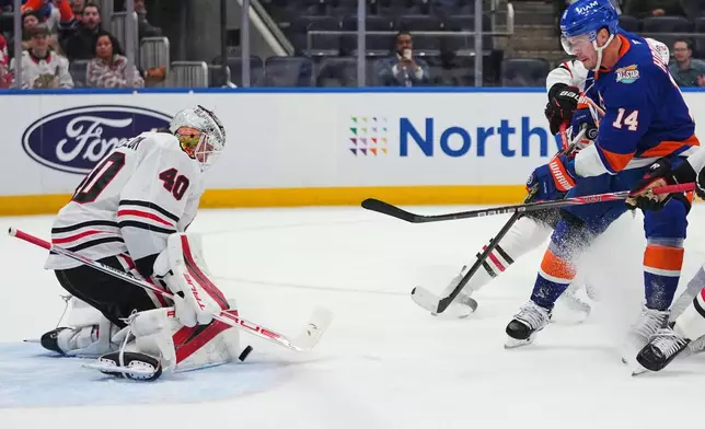 Chicago Blackhawks goaltender Arvid Soderblom (40) stops a shot by New York Islanders' Bo Horvat (14) during the second period of an NHL hockey game Thursday, Oct. 8, 2026, in Elmont, N.Y. (AP Photo/Frank Franklin II)