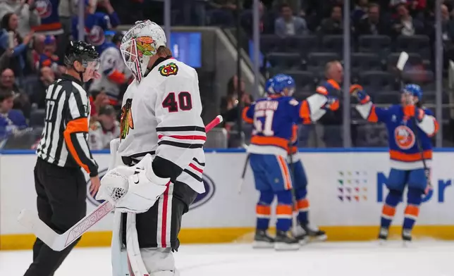 Chicago Blackhawks goaltender Arvid Soderblom (40) looks away as New York Islanders' Emil Heineman (51) celebrates with teammates after scoring a goal during the second period of an NHL hockey game Thursday, Oct. 8, 2026, in Elmont, N.Y. (AP Photo/Frank Franklin II)