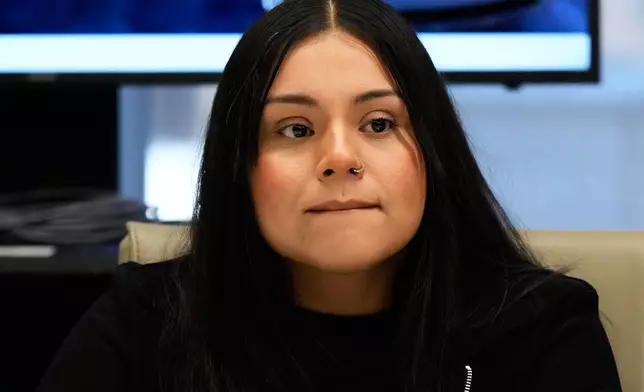 Marimar Martinez, a Chicago woman who was shot by a Border Patrol agent last year, listens to attorney Christopher Parente at a press conference Monday, Oct. 5, 2026, in Chicago. (AP Photo/Nam Y. Huh)