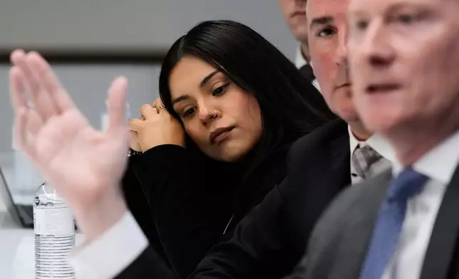 Marimar Martinez, a Chicago woman who was shot by a Border Patrol agent last year, listens to attorney Michael Gallagher at a press conference Monday, Oct. 5, 2026, in Chicago. (AP Photo/Nam Y. Huh)