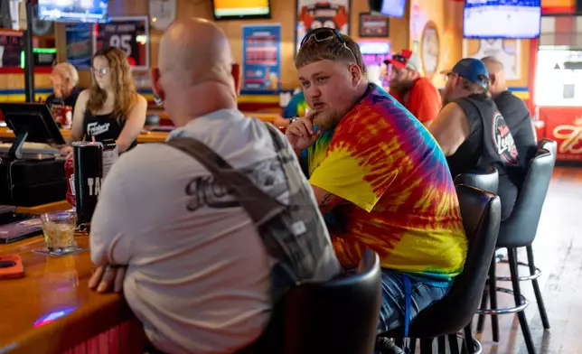 UAW Local 402 member Kyle Bos, right, has beer with Hal "Tank" Dunithan, left, and fellow UAW Local 402 members at Fricker's restaurant and bar in Springfield, Ohio, on Wednesday, Sept. 30, 2026, on old Navistar's last day at its Springfield plant. (AP Photo/Carolyn Kaster)