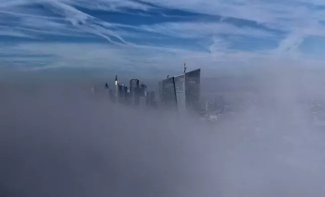 Fog drifts by the European Central Bank, right, on the occasion of the announcement of the resignation of European Central Bank President Christine Lagarde, in Frankfurt, Germany, Thursday, Oct. 29, 2026. (AP Photo/Michael Probst)