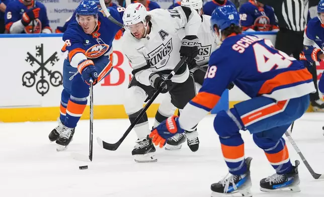 New York Islanders' Logan Stanley (8) fights for control of the puck with -Los Angeles Kings' Artemi Panarin (10) during the first period of an NHL hockey game Thursday, Oct. 22, 2026, in Elmont, N.Y. (AP Photo/Frank Franklin II)