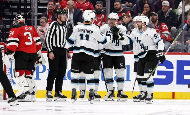 Utah Mammoth defenseman MacKenzie Weegar (52) celebrates with teammates after scoring a goal past New Jersey Devils goaltender Jake Allen during the second period of an NHL hockey game Tuesday, Oct. 6, 2026, in Newark, N.J. (AP Photo/Adam Hunger)