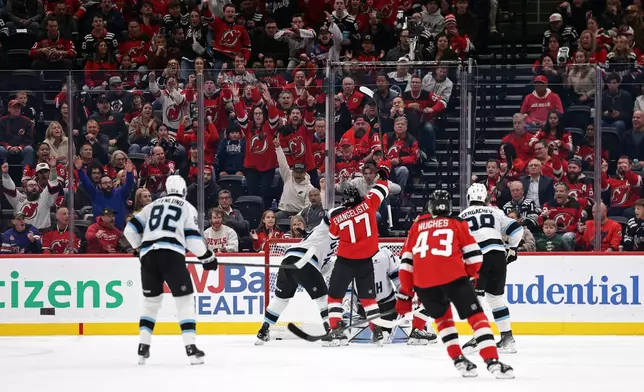 New Jersey Devils right wing Luke Evangelista (77) reacts after scoring a goal during the first period of an NHL hockey game against the Utah Mammoth, Tuesday, Oct. 6, 2026, in Newark, N.J. (AP Photo/Adam Hunger)