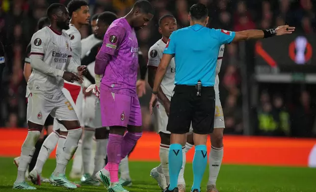 AC Milan's goalkeeper Mike Maignan, center, is ordered to leave the field after he was shown a red card during the Europa League soccer match between Bournemouth and AC Milan in Bournemouth, England, Thursday, Oct. 22, 2026. (AP Photo/Alastair Grant)