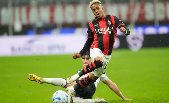 AC Milan's Omari Hutchinson, top, and Atalanta's Relja Obric challenge for the ball during the Serie A soccer match between AC Milan and Atalanta in Milan, Italy, Sunday, Oct. 18, 2026. (AP Photo/Luca Bruno)