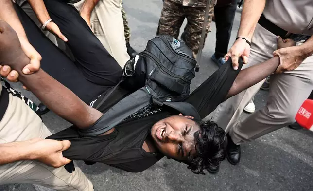 Security personnel detain a protester during a youth demonstration demanding the resignation of the country's election chief Gyanesh Kumar, in New Delhi, India, Sunday, Oct. 11, 2026. (AP Photo/Vipin)