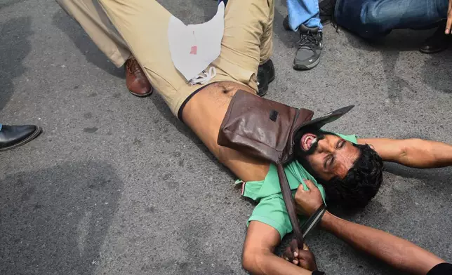 Police detain a protester during a demosntrationt demanding the resignation of Chief Election Commissioner Gyanesh Kumar during a protest in New Delhi, India, Sunday, Oct. 11, 2026. (AP Photo/Prabhat Mehrota)