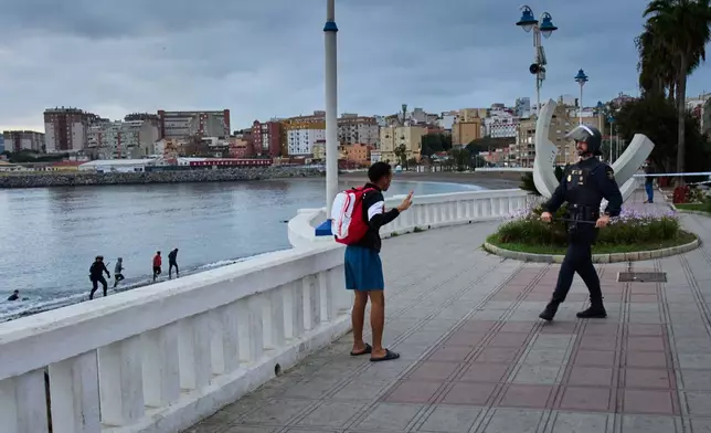 A migrant who tried to flee during the eviction of a makeshift camp on Benítez Beach surrenders to Spanish National Police officers in the Spanish enclave of Ceuta, Tuesday, Sept. 29, 2026. (AP Photo/Bernat Armangue)