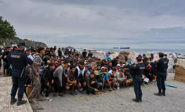 Migrants wait for food distribution to begin on El Trampolín Beach in the Spanish enclave of Ceuta, Monday, Sept. 28, 2026. (AP Photo/Bernat Armangue)
