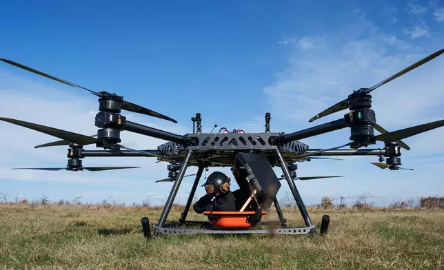 A representative of the SkyFall drone company climbs into a medical module of the SkyGate drone before a demonstration flight at an undisclosed location in Ukraine, Wednesday, Oct. 14, 2026. (AP Photo/Evgeniy Maloletka)