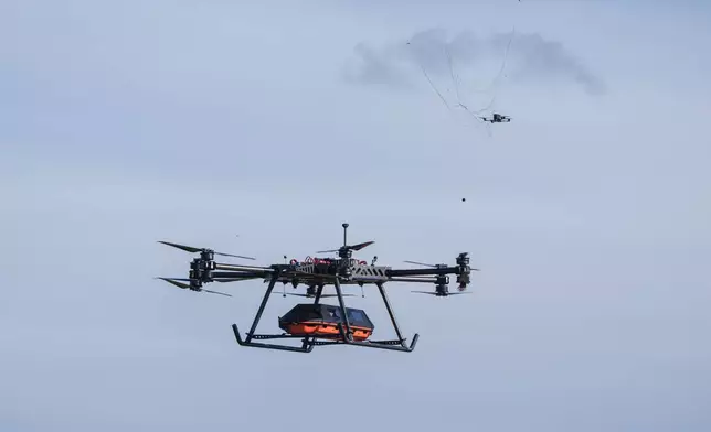 The SkyGate drone, made by the SkyFall drone company and equipped with a medical module, deploys a net designed to intercept aerial threats commonly encountered along Ukraine's front line at an undisclosed location in Ukraine, Wednesday, Oct. 14, 2026. (AP Photo/Evgeniy Maloletka)