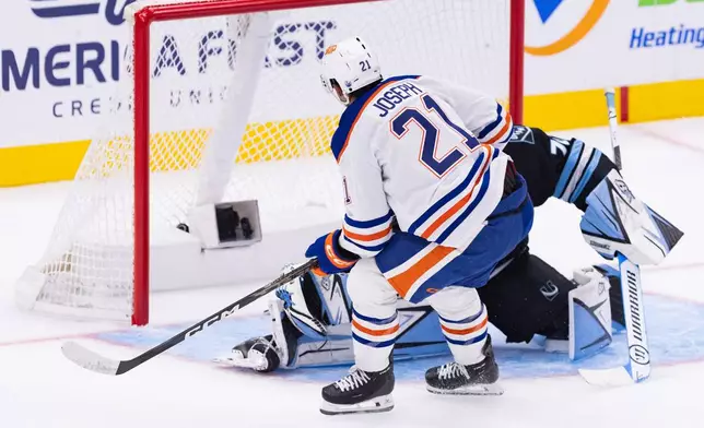 Edmonton Oilers right wing Mathieu Joseph (21) scores the goal against Utah Mammoth goalie Karel Vejmelka (70) during the first period of an NHL hockey game Saturday, Oct. 17, 2026, in Salt Lake City. (AP Photo/Melissa Majchrzak)