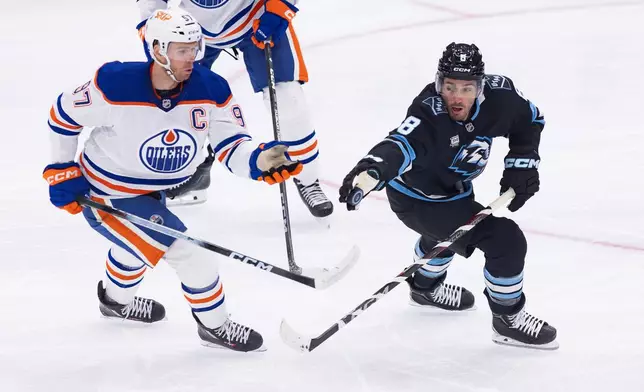 Utah Mammoth center Nick Schmaltz (8) stops the puck against Edmonton Oilers center Connor McDavid (97) during the first period of an NHL hockey game Saturday, Oct. 17, 2026, in Salt Lake City. (AP Photo/Melissa Majchrzak)