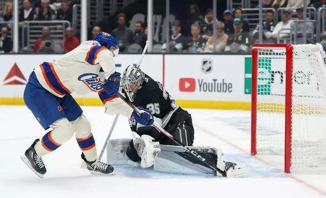 Edmonton Oilers center Connor McDavid (97), left, shoots past Los Angeles Kings goaltender Darcy Kuemper (35), right, to score during the first period of an NHL hockey game Tuesday, Oct. 13, 2026, in Los Angeles. (AP Photo/Caroline Brehman)