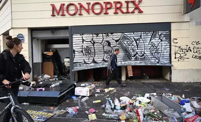 A man walks past a looted store the day after a demonstration against rising living costs and in solidarity with students’ grievances, in Paris, Sunday, Oct. 18, 2026. (AP Photo/Emma Da Silva)